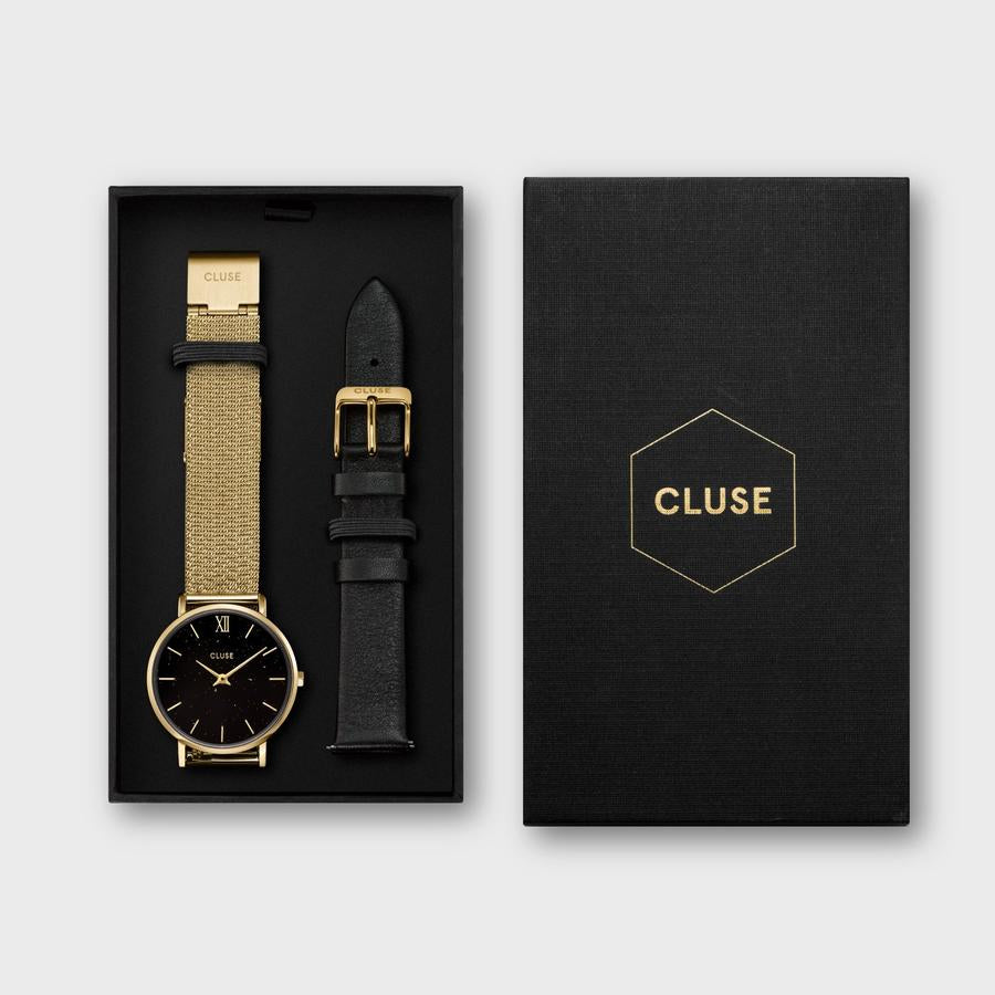This gorgeous CLUSE gift box combines the gold coloured minimalist Minuit, with an additional black leather strap. This gold coloured Minuit watch has a special mesh strap and a stunning black dial adorned with gold coloured flecks. All Minuit watch straps are interchangeable, so you can easily customise your stainless steel case to match your mood. Style your day in a gorgeous gold colour or switch to sophisticated black. Presented in a modern geometric pattern gift box.