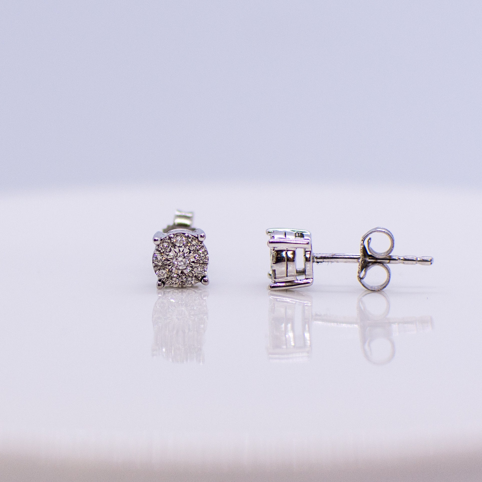 5mm wide diamond set stud earrings. 0.15ct of round brilliant cut diamonds.  Illusion setting.  9ct white gold.   Butterfly backs.