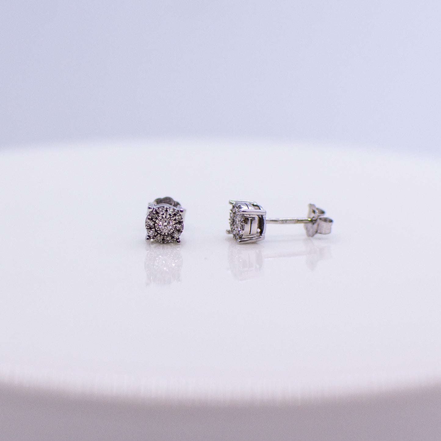 4mm wide stud earring set with diamonds. 0.10ct of round brilliant cut diamonds.  Illusion setting.  9ct white gold.   Butterfly backs.