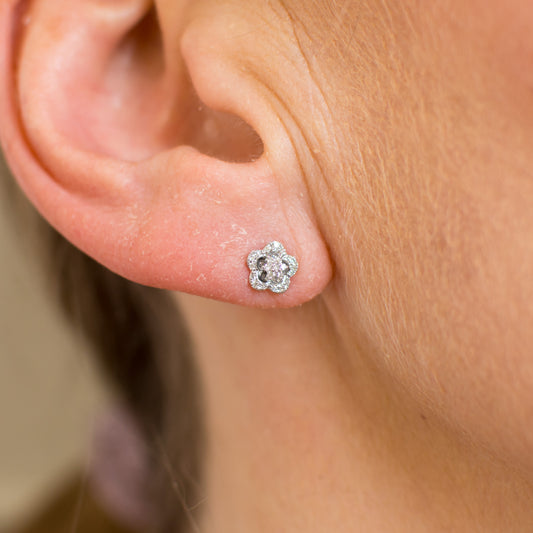 These pretty 9ct white gold stud earrings are set with round brilliant cut diamonds.  The floral design is delicate and very attractive. 9ct white gold