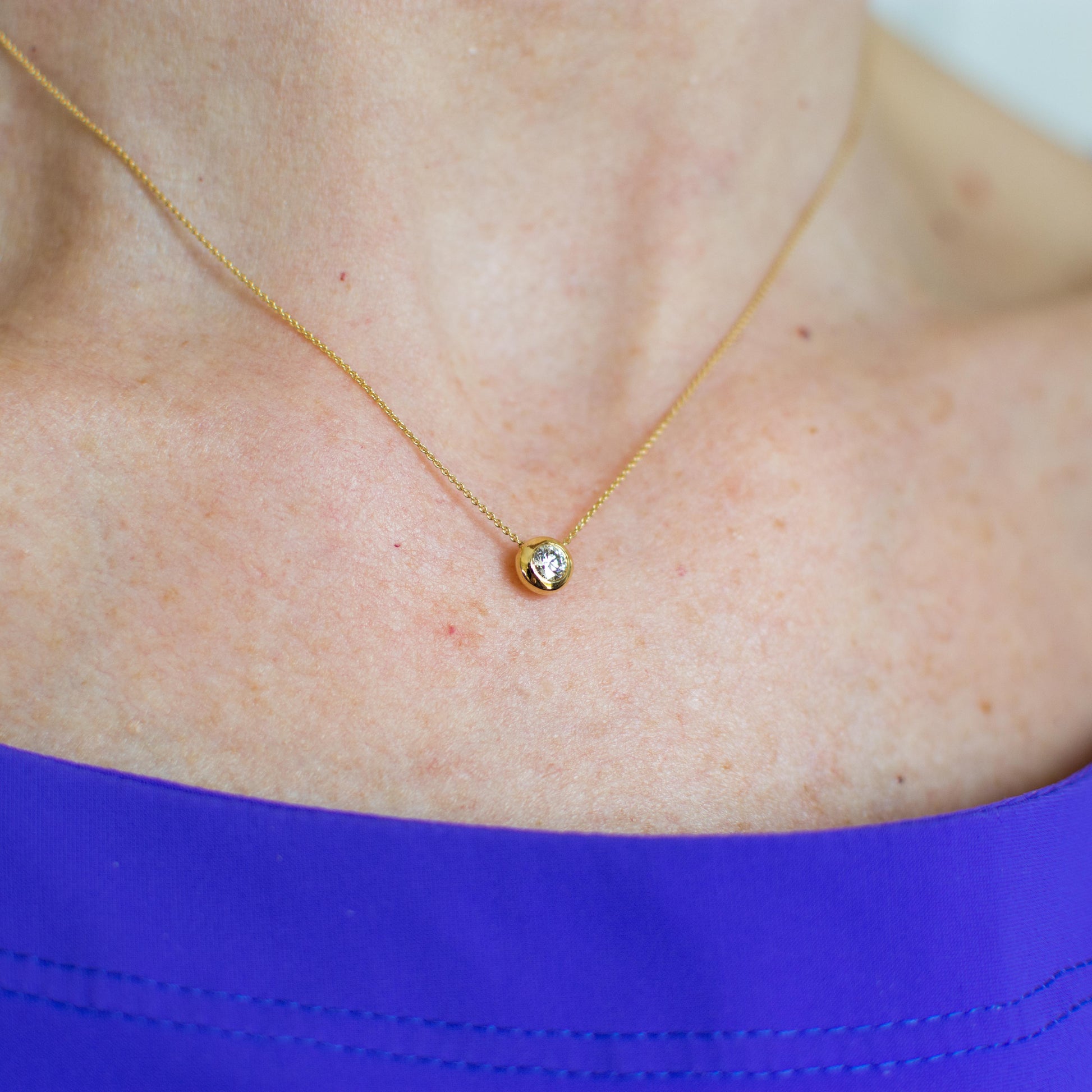 This is a gorgeous classic necklace, ideal for everyday wear.  A single round brilliant cut diamond, bezel set 6mm x 6mm.  0.14ct approximately.  18ct yellow gold.  The chain passes through the pendant.  16-18 inch long adjustable 18ct yellow gold fine trace chain with lobster clasp.