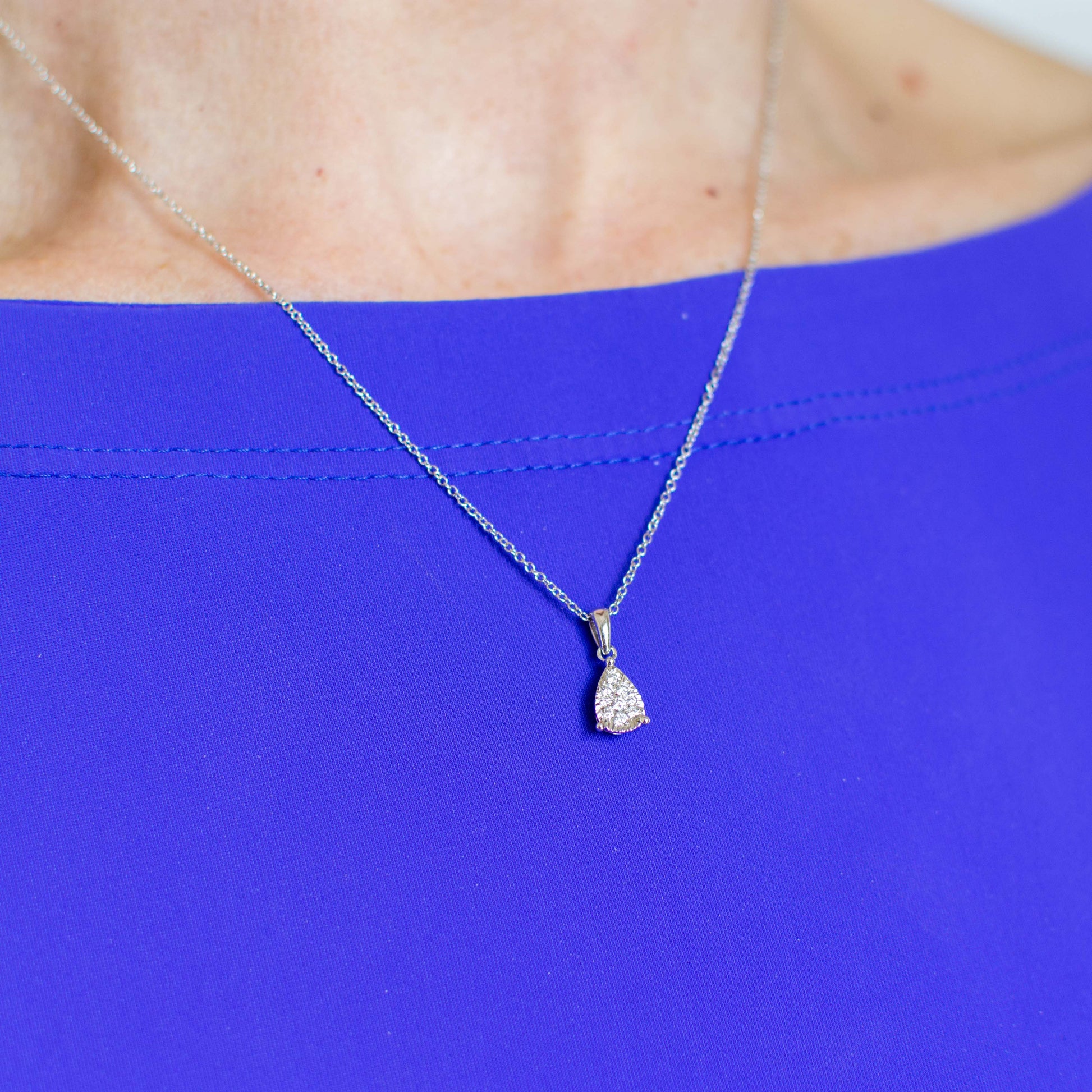 This beautiful necklace features a pear/teardrop shaped pendant set with nine round brilliant cut diamonds . 9ct white gold.   16-18" adjustable 9ct white gold fine trace chain with bolt ring clasp.