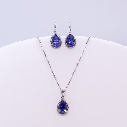 These sterling silver pear shaped drop earrings set with glittering cubic zirconia stones in created Tanzanite and white accompanied by the matching necklace are the perfect addition to any outfit. Product details: Product materials: 925 sterling silver, cubic zirconia Chain length: 44cm inch fine diamond cut curb chain Pendant dimensions:  20mm L x 10mm W Earring dimensions:  24mm L x 10mm W Drop earrings with integrated CZ set German wires.