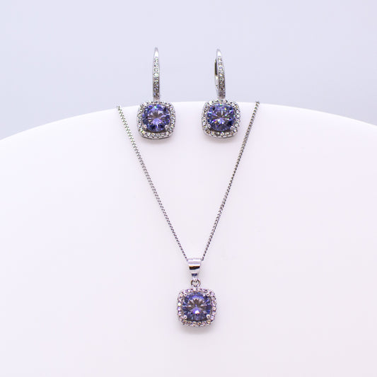 These sterling silver cushion shaped drop earrings set with glittering cubic zirconia stones in created Tanzanite colour and white accompanied by the matching necklace are the perfect addition to any outfit. Product details: Product materials: 925 sterling silver, cubic zirconia Chain length: 44cm inch fine diamond cut curb chain Pendant dimensions:  18mm L x 10mm W Earring dimensions:  22mm L x 10mm W Drop earrings with integrated CZ set German wires.