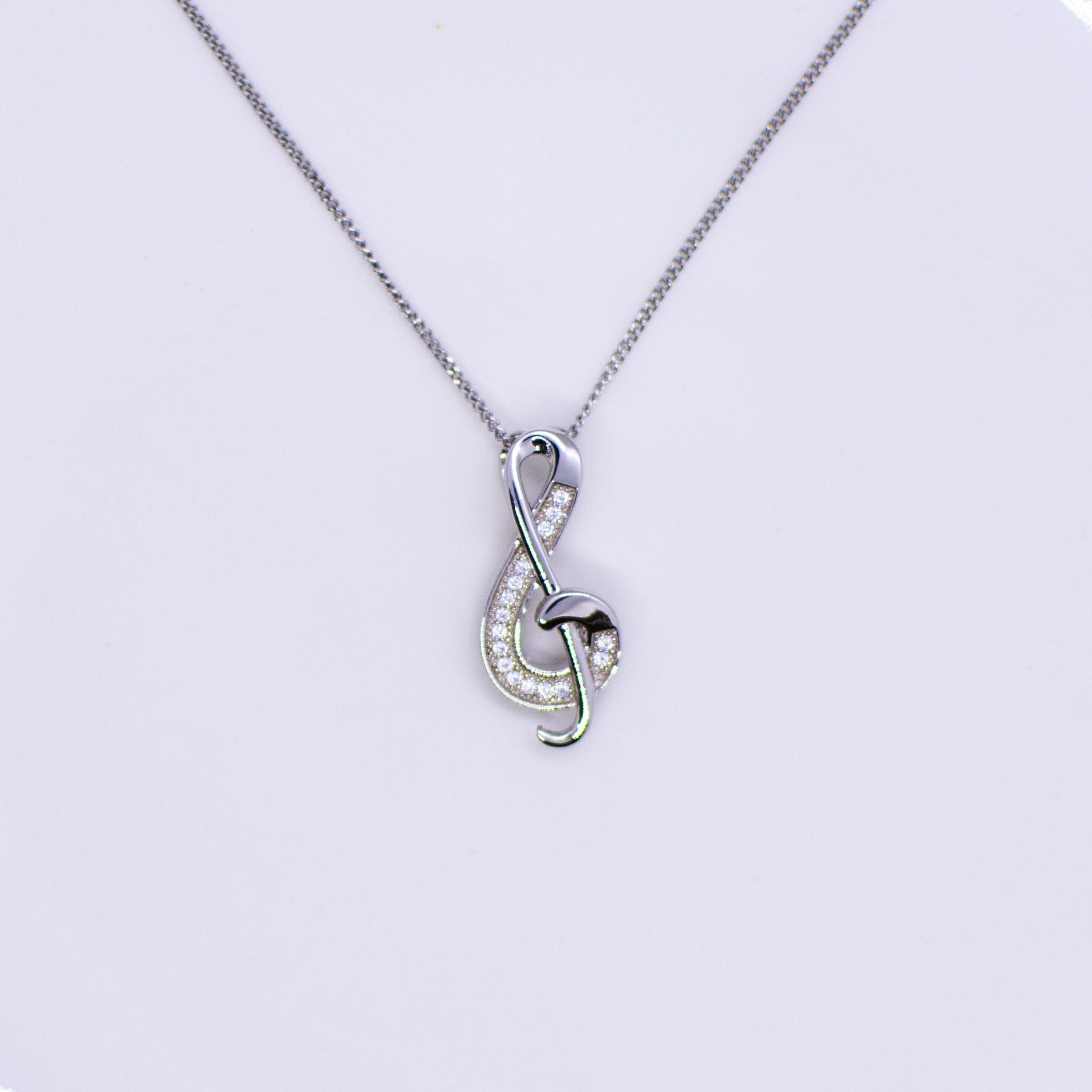 Silver CZ set Treble Clef slider pendant and chain This pretty Treble Clef is set with with glittering cubic zirconia stones.  An ideal necklace choice for music lovers of all ages. Product details: Product materials: 925 sterling silver, cubic zirconia Pendant dimensions:  22mm L x 9mm W Chain length: 44cm fine diamond cut curb chain