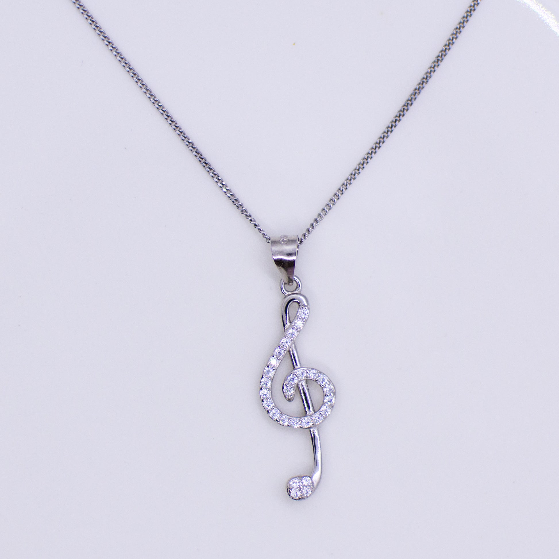 Silver CZ set Treble Clef pendant and chain This pretty Treble Clef is set with with glittering cubic zirconia stones.  An ideal necklace choice for music lovers of all ages. Product details: Product materials: 925 sterling silver, cubic zirconia Pendant dimensions:  33mm L x 9mm W Chain length: 44cm fine diamond cut curb chain
