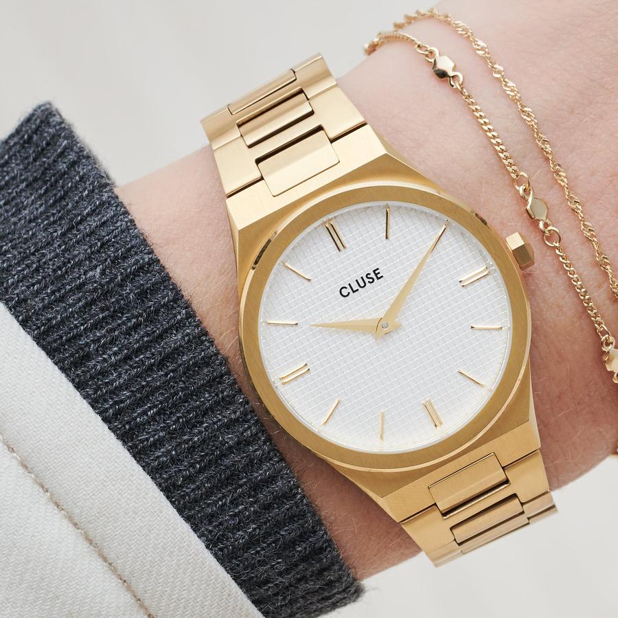 Strong. Bold. Beautiful. An integrated gold colour bracelet and multi-faceted case, combining brushed and highly polished elements. Upgrade your wrist game with this utterly chic stainless steel watch. Featuring a snow white grid dial and hint of joie de vivre. A celebration of your most powerful moments in life. Water resistance: 5 ATM. We will adjust the size of this strap in store.  