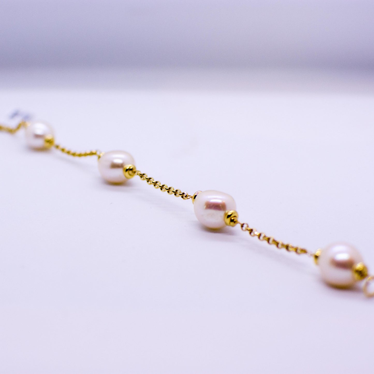 18ct Gold Cultured Freshwater Pearl and Chain Bracelet Pearl dimensions: 10mm x 12mm approximately Diamond cut 2mm gauge solid trace chain 19cm long 18ct yellow gold This item can be ordered in a variety of lengths.  Please contact us for custom requirements.