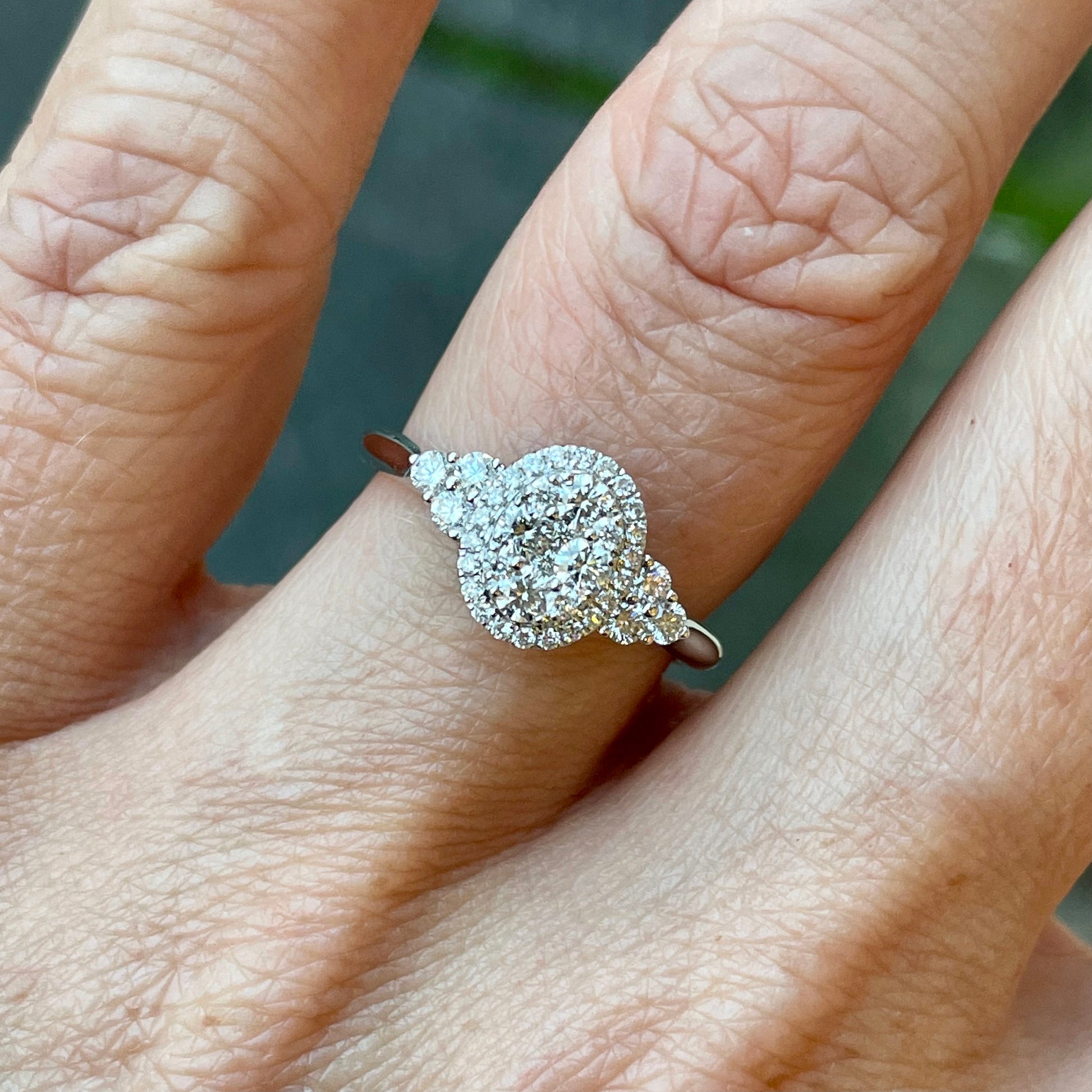 This oval cluster diamond engagement ring  is a complete classic.  Its simplicity is so romantic.  The Details...  One 18ct white gold diamond engagement ring.  Diamond halo cluster in an oval shape with trio shoulders. 0.62ct in total of diamonds.  Colour G.  Clarity VS.  18ct white gold.  Size N.