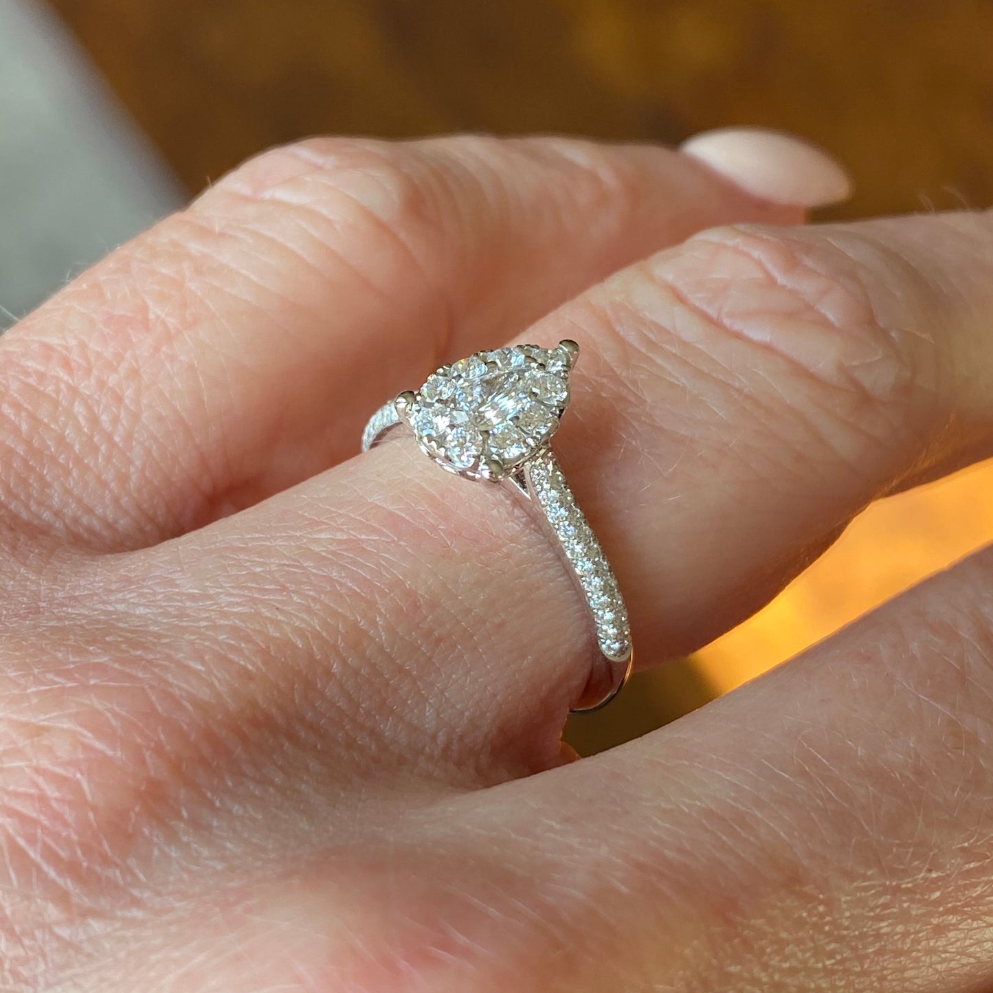 This pear cluster diamond engagement ring  is a complete classic.  Its simplicity is so romantic. The Details... One 18ct white gold diamond engagement ring.  Diamond halo cluster in an pear shape with pavé diamond-set shoulders. 0.74ct in total of diamonds.  Colour G.  Clarity VS. Centre stone: 0.22ct Melée: 0.52ct 18ct white gold.  Size M