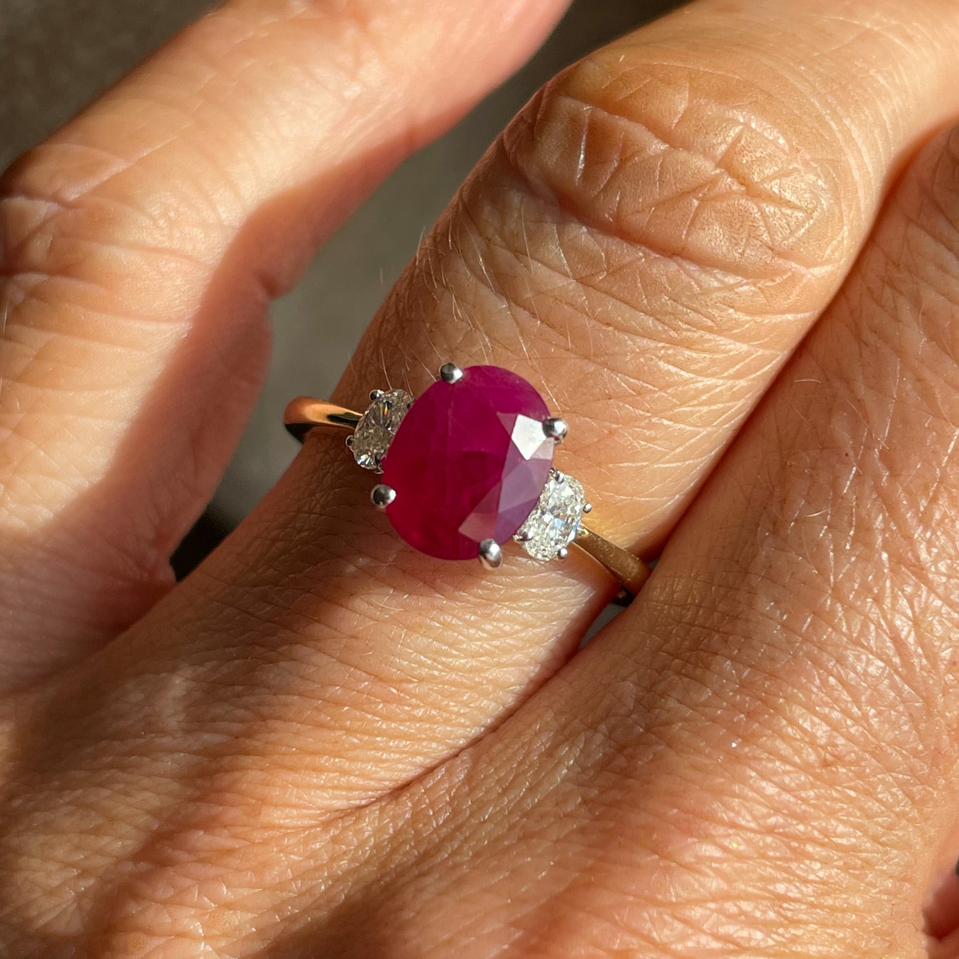18ct yellow gold ruby and diamond trilogy ring.   A single oval cut ruby 2.46ct with a single oval cut diamond on either side 0.25ct in total.     Ruby is the birthstone of July and traditionally Ruby is the stone for 40th Birthdays and 40th Wedding Anniversaries. 