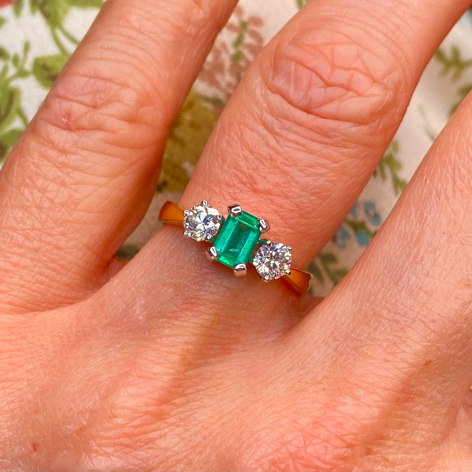 18ct Gold Emerald & Diamond Three Stone Ring  Emerald cut Emerald: 4mm x 6.2mm 0.77ct set in 18ct white gold   Diamonds: 0.54ct H SI set in 18ct white gold  Setting dimensions: 13.6 mm x 7mm  Setting height: 6.2mm  2.8mm shank, Size O 18ct yellow gold   18ct yellow gold   Made in Ireland - Handmade