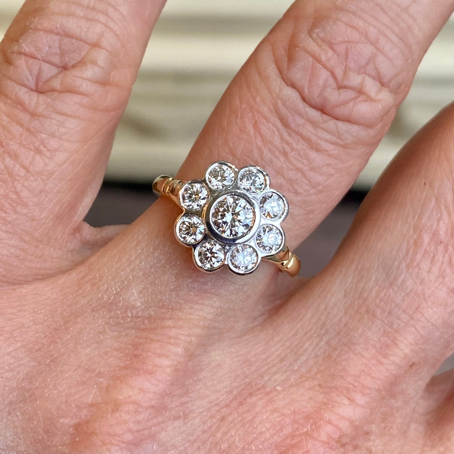 18ct Gold 1.02ct Diamond Flower Cluster Ring   Centre Diamond: 0.31ct  Eight Diamonds surrounding the Centre Diamond: 0.71ct in total.    All round brilliant cut diamonds, GH SI approximately.  18ct white gold rub-over setting.  18ct yellow gold shank size N.