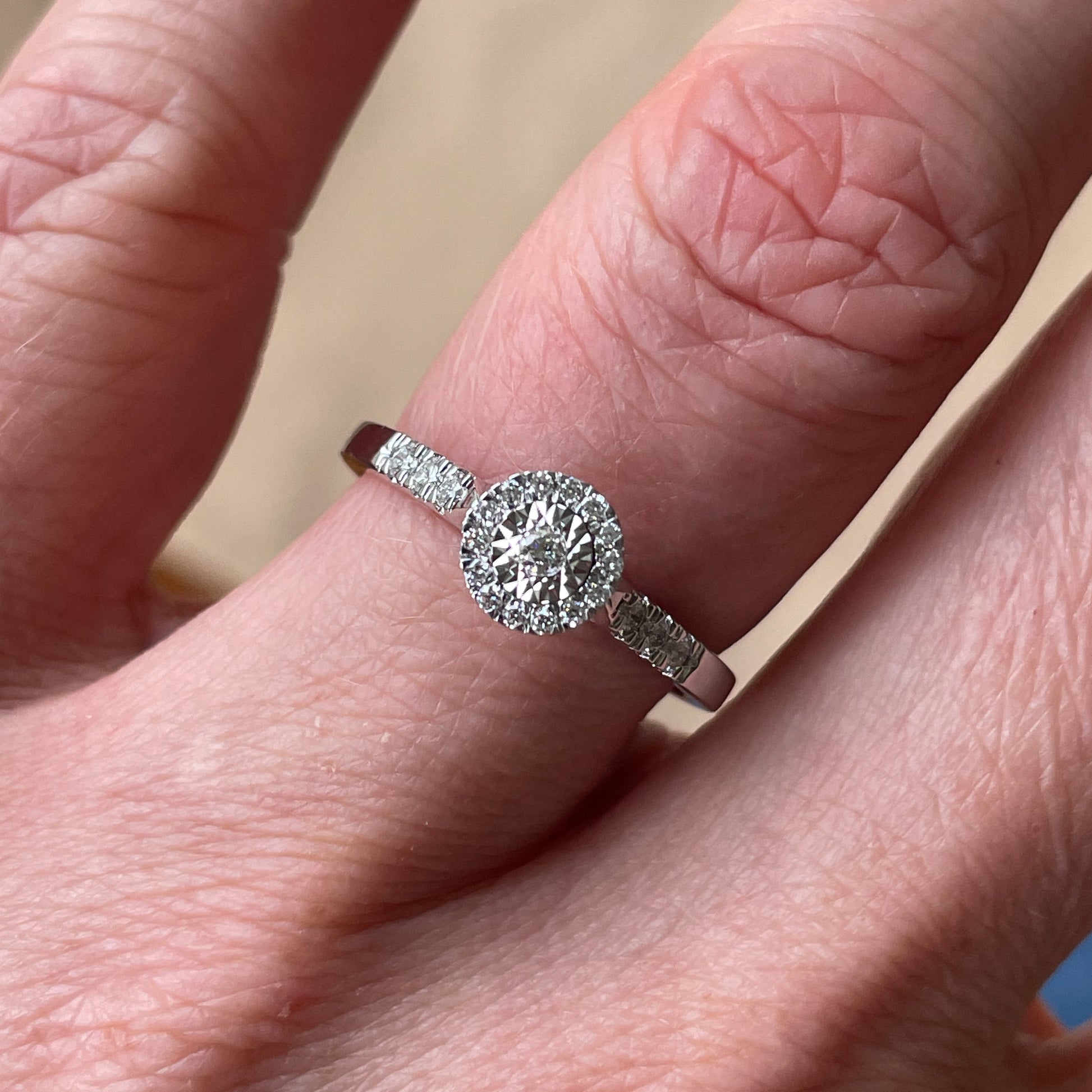 9ct White Gold Diamond Illusion Solitaire Engagement Ring 0.20ct in total approximately   This diamond engagement ring has diamond set shoulders.