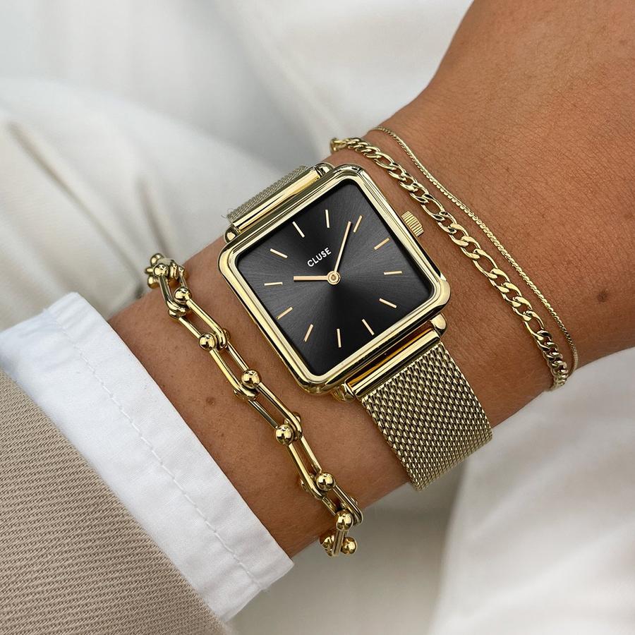 With a square case, rounded edges and clean, uncluttered face, La Tétragone watch for women is a play on line, shape and form. With its black dial and gold coloured case and mesh strap this watch gives a classic touch to any look. As with all our watches in the La Tétragone collection, the straps of this model can be interchanged with any 16 mm CLUSE watch straps. To change the battery, we recommend visiting your local jeweller.